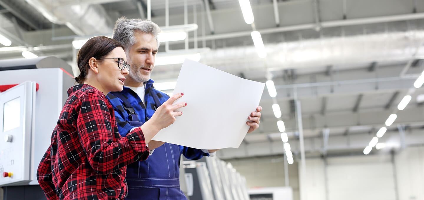 Workers looking at paper sheet