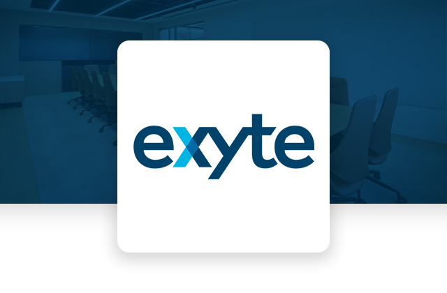 Modern conference room featuring a long table with multiple chairs arranged around it, large windows, and a wall-mounted screen. The Exyte logo is displayed in the top right corner, indicating the company's branding or office space.