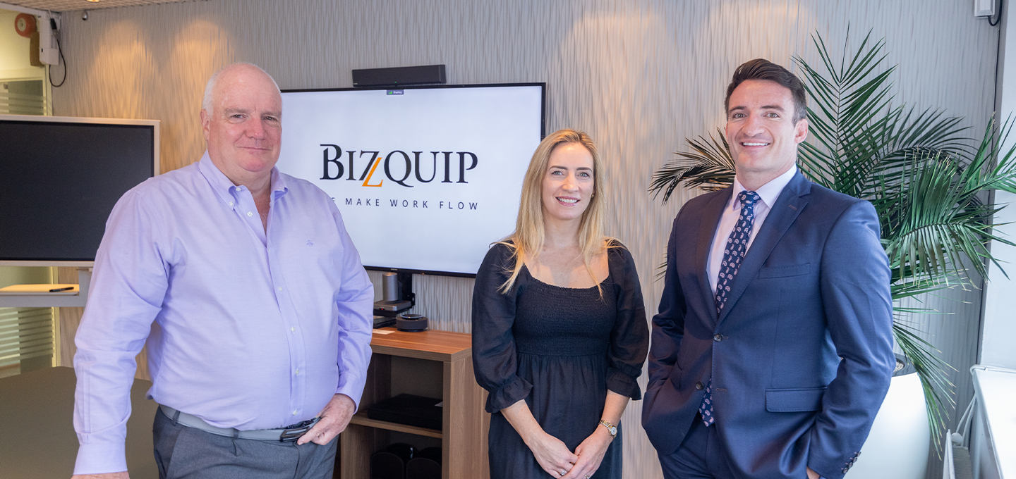 A group of people standing in front of a screen